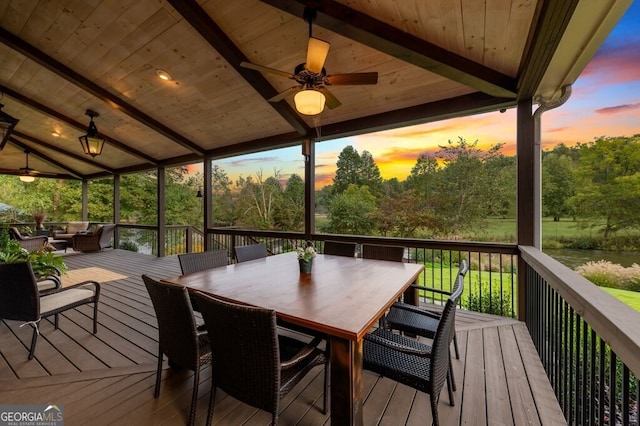 547 Toccoa River Ln, Mineral Bluff, GA 30559 - deck at dusk with ceiling fan, outdoor dining area, and view of wooded area