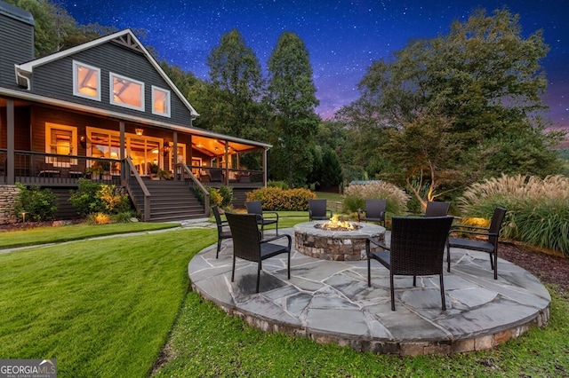 547 Toccoa River Ln, Mineral Bluff, GA 30559 - patio terrace at dusk with stairway, an outdoor fire pit, a lawn, and a patio