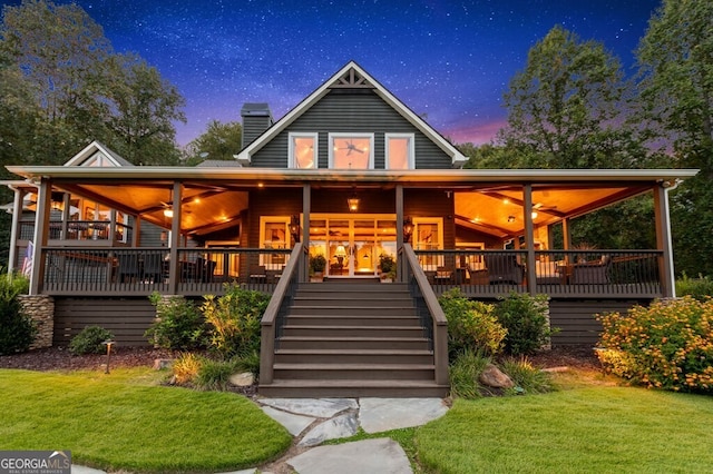 547 Toccoa River Ln, Mineral Bluff, GA 30559 - back of house at dusk featuring a chimney, stairway, and a lawn