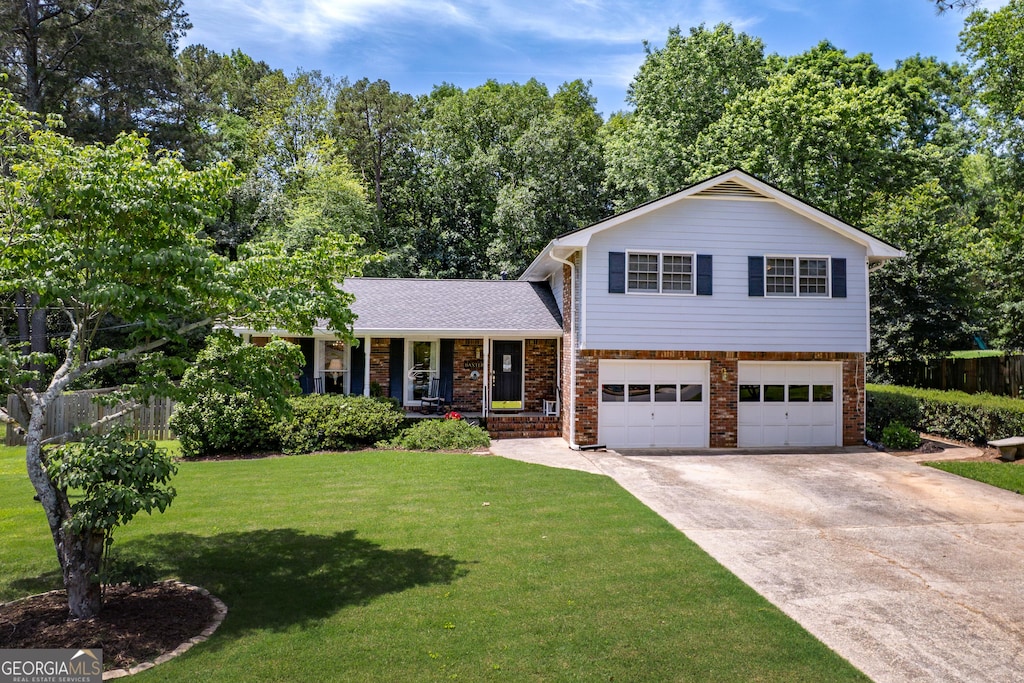 5778 Little Oak Trl, Stone Mountain, GA 30087 - split level home with covered porch, a garage, brick siding, and driveway