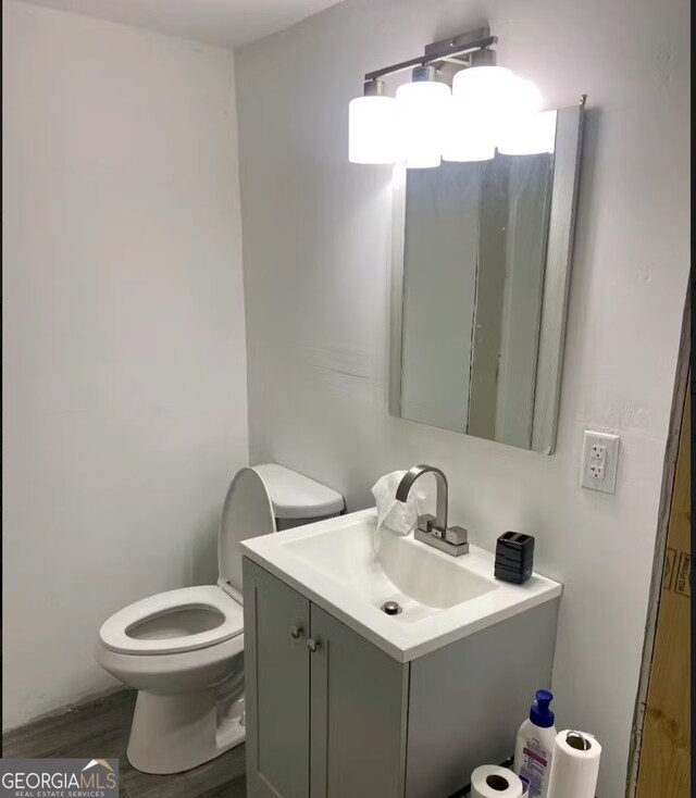8020 Ga Highway 272, Sandersville, GA 31082 - half bathroom featuring vanity, toilet, and wood finished floors