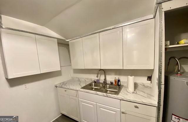 8020 Ga Highway 272, Sandersville, GA 31082 - kitchen with a sink, lofted ceiling, white cabinetry, water heater, and light stone countertops