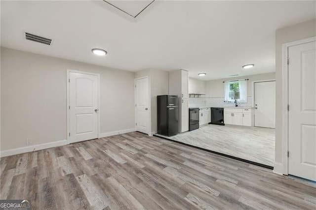 1268 Ladd St SW, Atlanta, GA 30310 - kitchen featuring black appliances, light wood-type flooring, white cabinetry, and baseboards