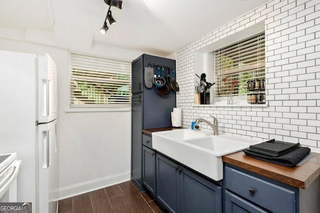677 Holmes St NW, Atlanta, GA 30318 - kitchen featuring wooden counters, tasteful backsplash, blue cabinets, dark wood-type flooring, and freestanding refrigerator