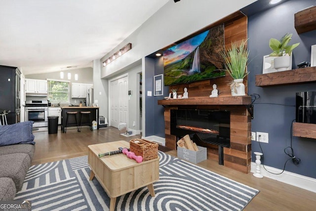 677 Holmes St NW, Atlanta, GA 30318 - living area featuring vaulted ceiling, wood finished floors, and a glass covered fireplace