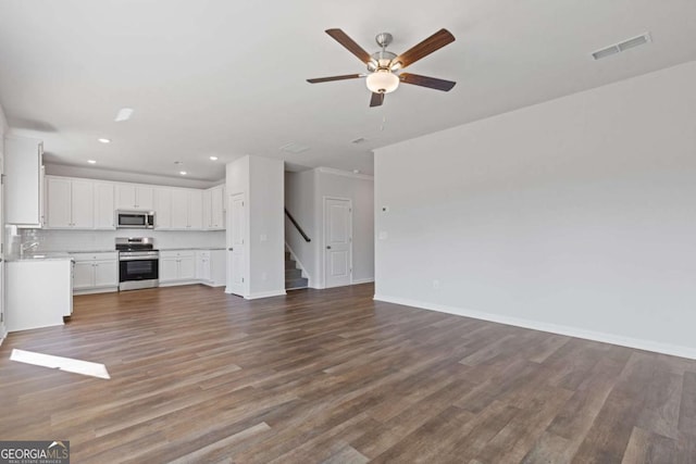 427 Buck Trl, Dallas, GA 30132 - unfurnished living room with ceiling fan, recessed lighting, wood finished floors, stairway, and baseboards