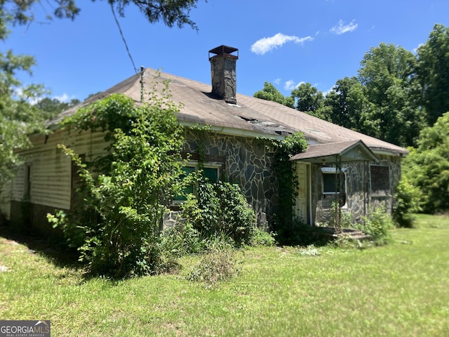 72 N Pomona Rd N, Hampton, GA 30228 - back of house with a chimney, stone siding, and a lawn