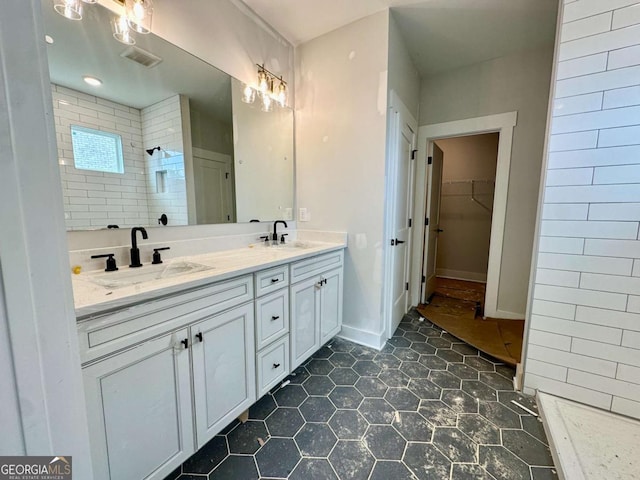 6819 Cambridge Dr, Flowery Branch, GA 30542 - bathroom featuring double vanity, a tile shower, a spacious closet, and tile patterned flooring