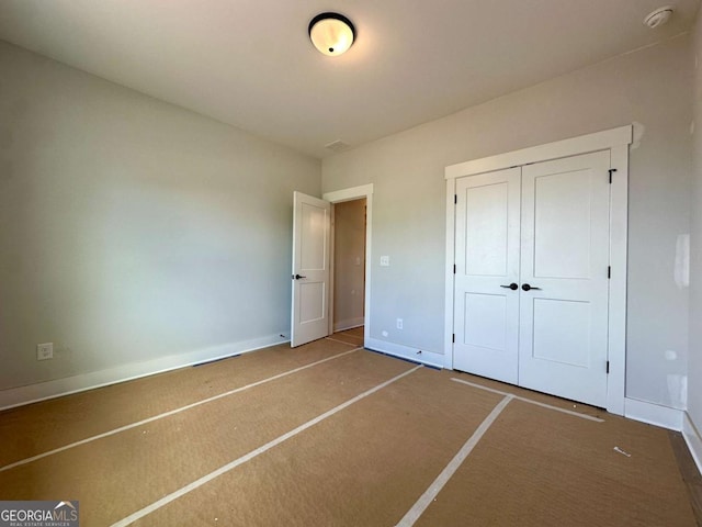 6819 Cambridge Dr, Flowery Branch, GA 30542 - unfurnished bedroom featuring baseboards, carpet flooring, and a closet
