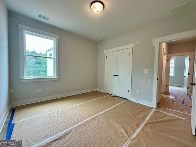 6819 Cambridge Dr, Flowery Branch, GA 30542 - unfurnished bedroom featuring a closet, baseboards, and carpet