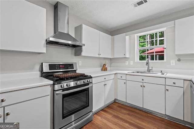 1047 Woodsong Pass Ct, Lawrenceville, GA 30043 - kitchen with wall chimney exhaust hood, stainless steel gas range oven, a sink, white cabinets, and a textured ceiling