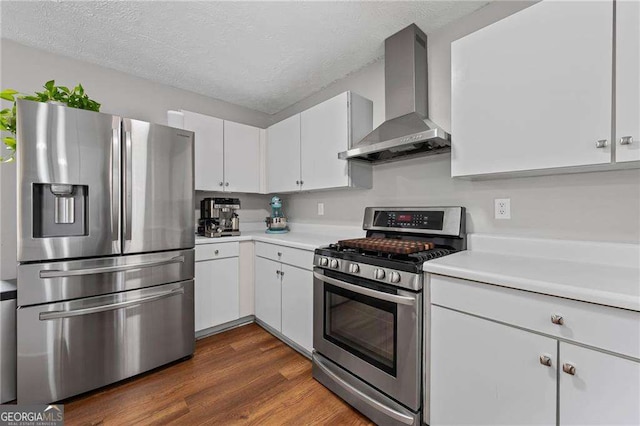 1047 Woodsong Pass Ct, Lawrenceville, GA 30043 - kitchen featuring stainless steel appliances, wall chimney range hood, light countertops, white cabinetry, and a textured ceiling