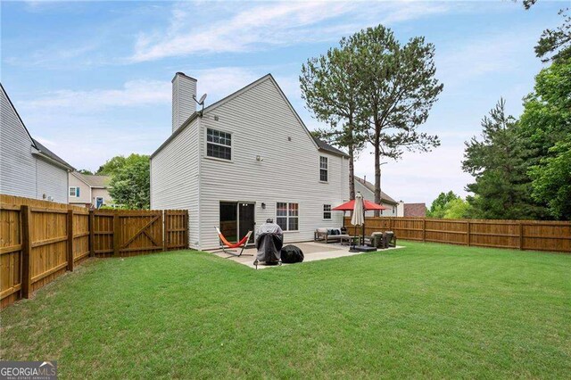 1047 Woodsong Pass Ct, Lawrenceville, GA 30043 - back of house featuring a patio area and a chimney