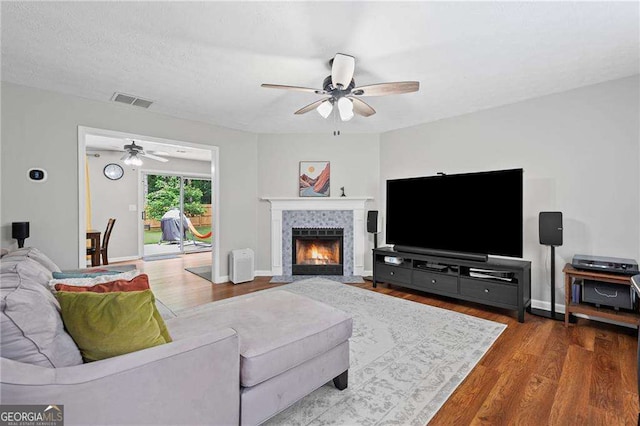 1047 Woodsong Pass Ct, Lawrenceville, GA 30043 - living area featuring a ceiling fan, wood finished floors, a tile fireplace, and baseboards