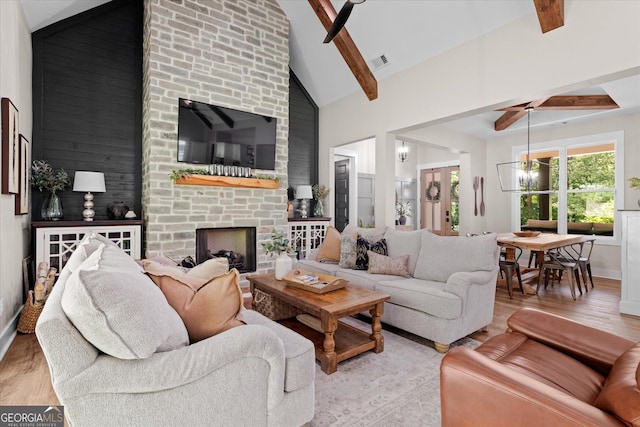 2490 S Carroll St, Villa Rica, GA 30180 - living room featuring beamed ceiling, light wood-type flooring, a fireplace, and high vaulted ceiling