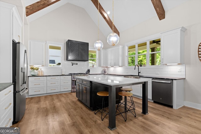 2490 S Carroll St, Villa Rica, GA 30180 - kitchen featuring appliances with stainless steel finishes, a kitchen breakfast bar, white cabinets, custom exhaust hood, and beamed ceiling