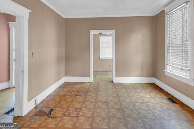 507 W 35th St, Savannah, GA 31415 - empty room with healthy amount of natural light, ornamental molding, baseboards, and wood walls