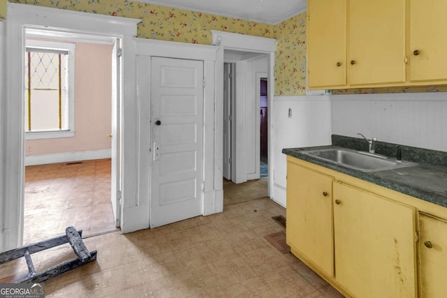 507 W 35th St, Savannah, GA 31415 - kitchen featuring wallpapered walls, a sink, wainscoting, light floors, and dark countertops