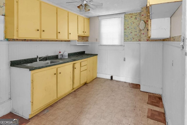 507 W 35th St, Savannah, GA 31415 - kitchen featuring a sink, a wainscoted wall, a ceiling fan, light flooring, and dark countertops