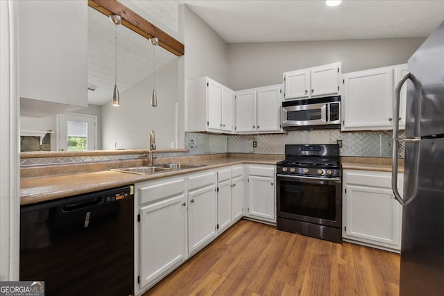 3357 Saddleton Way, Douglasville, GA 30134 - kitchen featuring appliances with stainless steel finishes, vaulted ceiling, a sink, backsplash, and white cabinetry