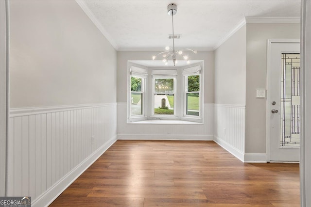 3357 Saddleton Way, Douglasville, GA 30134 - unfurnished dining area featuring a chandelier, wood finished floors, a wainscoted wall, and crown molding