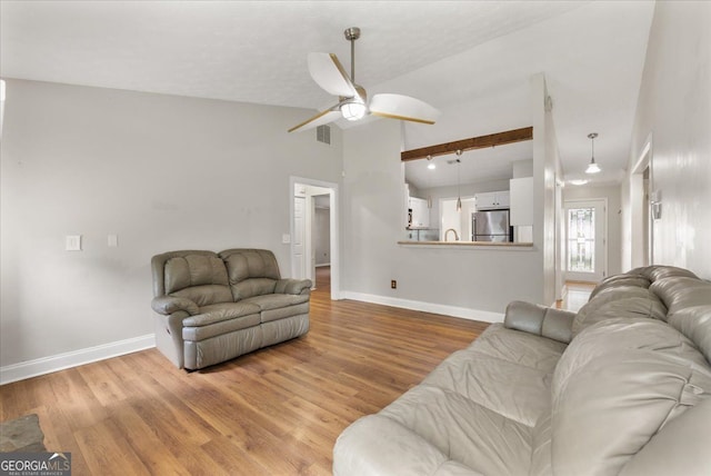 3357 Saddleton Way, Douglasville, GA 30134 - living room with a ceiling fan, lofted ceiling, baseboards, and light wood-style flooring