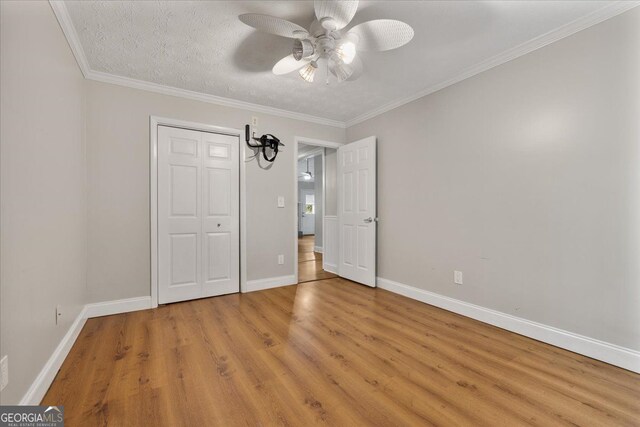 3357 Saddleton Way, Douglasville, GA 30134 - unfurnished bedroom with light wood-style flooring, baseboards, a closet, a ceiling fan, and crown molding