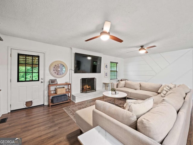 150 Archer Rd, Colbert, GA 30628 - living room with a textured ceiling, ceiling fan, a brick fireplace, and wood finished floors