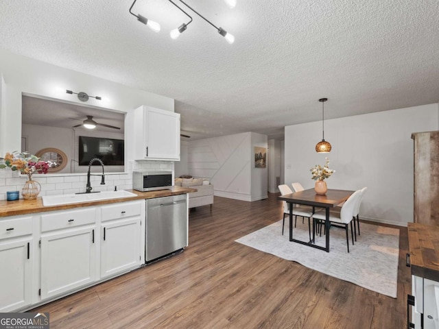150 Archer Rd, Colbert, GA 30628 - kitchen with stainless steel dishwasher, white microwave, a sink, a textured ceiling, and light wood finished floors