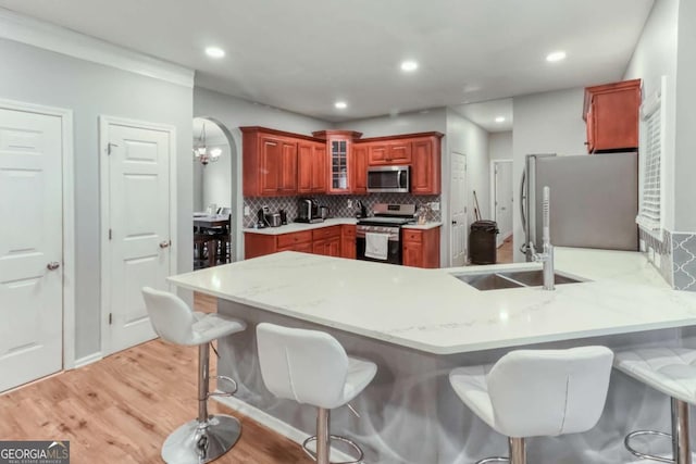 3898 Heritage Oaks Dr, Powder Springs, GA 30127 - kitchen featuring stainless steel appliances, a peninsula, decorative backsplash, light wood-type flooring, and glass insert cabinets