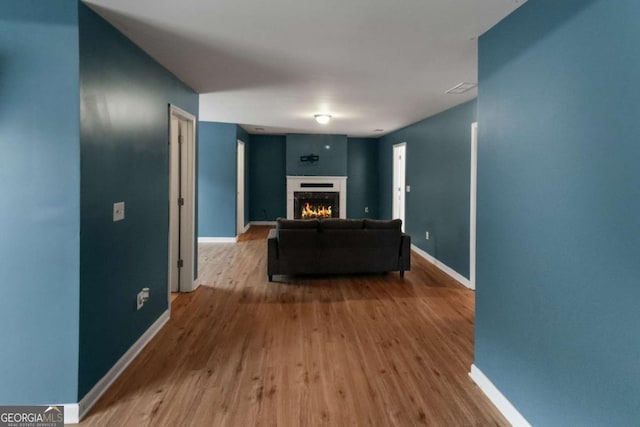 3898 Heritage Oaks Dr, Powder Springs, GA 30127 - living area with wood finished floors, baseboards, and a warm lit fireplace