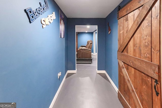 3898 Heritage Oaks Dr, Powder Springs, GA 30127 - corridor with a barn door, baseboards, and finished concrete floors