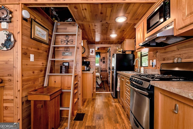 76 Hidden Valley Rd, Cleveland, GA 30528 - kitchen with appliances with stainless steel finishes, wood finished floors, wooden walls, under cabinet range hood, and wooden ceiling