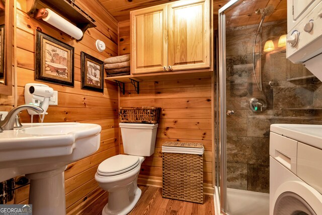 76 Hidden Valley Rd, Cleveland, GA 30528 - bathroom featuring washer / clothes dryer, a stall shower, toilet, wood finished floors, and wood walls