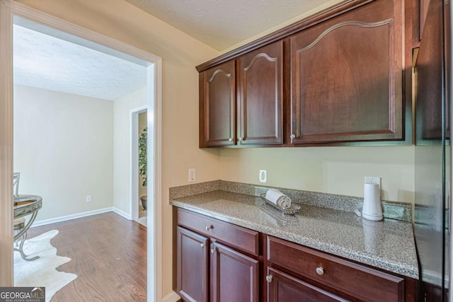 3947 Veracruz Ct, Decatur, GA 30034 - kitchen featuring light wood-type flooring, baseboards, light stone countertops, a textured ceiling, and black refrigerator