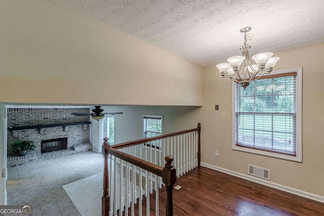 3947 Veracruz Ct, Decatur, GA 30034 - stairs with a chandelier, baseboards, a textured ceiling, a ceiling fan, and a brick fireplace
