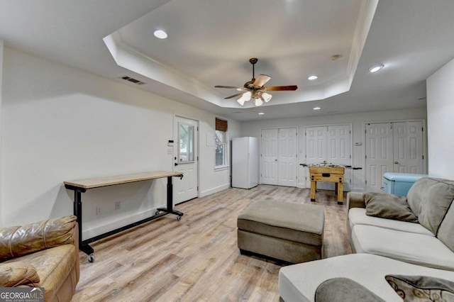 3760 Ansley Park Dr, Suwanee, GA 30024 - living room featuring a raised ceiling, recessed lighting, ceiling fan, light wood-type flooring, and baseboards