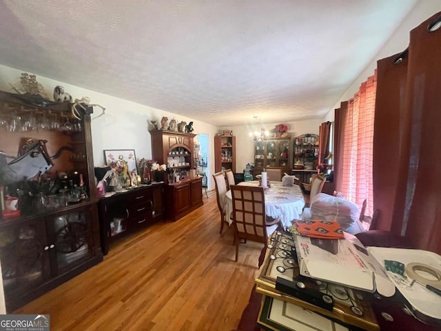 3750 Dial Mill Rd NE, Conyers, GA 30013 - dining space with a chandelier, wood finished floors, and a textured ceiling