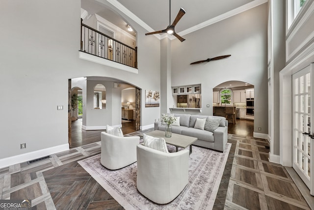 115 Hopewell Grove Dr, Milton, GA 30004 - living area featuring arched walkways, ceiling fan, baseboards, crown molding, and a high ceiling