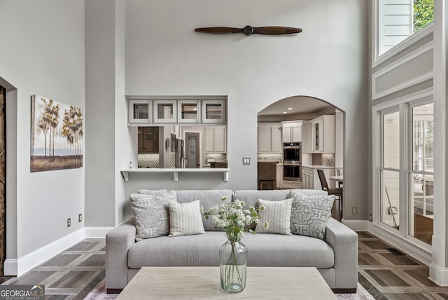 115 Hopewell Grove Dr, Milton, GA 30004 - living room with a high ceiling, ceiling fan, baseboards, and arched walkways