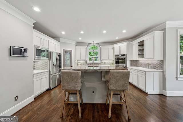 115 Hopewell Grove Dr, Milton, GA 30004 - kitchen featuring stainless steel appliances, a sink, a breakfast bar, decorative backsplash, and a center island