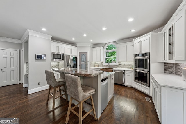 115 Hopewell Grove Dr, Milton, GA 30004 - kitchen featuring stainless steel appliances, crown molding, a breakfast bar area, recessed lighting, and white cabinets