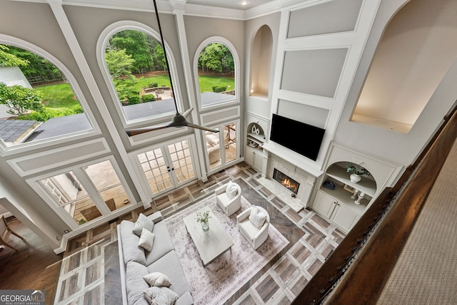 115 Hopewell Grove Dr, Milton, GA 30004 - living room featuring crown molding, french doors, a warm lit fireplace, a high ceiling, and built in features