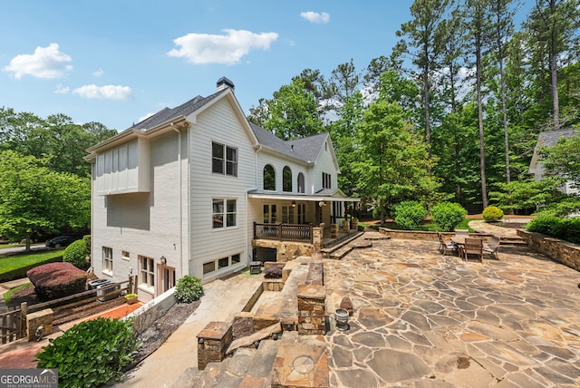 115 Hopewell Grove Dr, Milton, GA 30004 - rear view of house featuring a patio area, a garage, a chimney, and outdoor dining space
