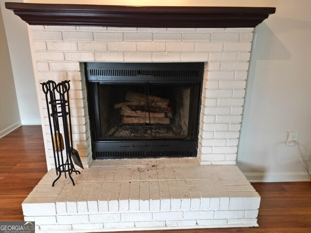 605 Candler St Unit A8, Gainesville, GA 30501 - detailed view of a brick fireplace, baseboards, and wood finished floors