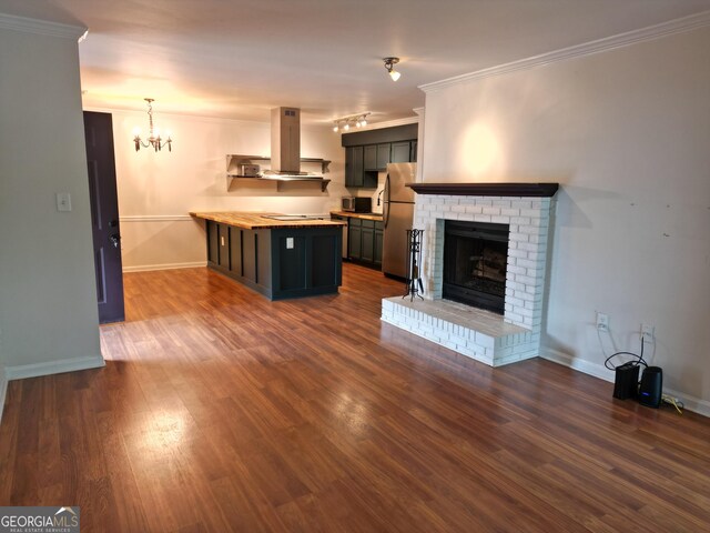 605 Candler St Unit A8, Gainesville, GA 30501 - unfurnished living room featuring crown molding, dark wood finished floors, baseboards, a brick fireplace, and a chandelier