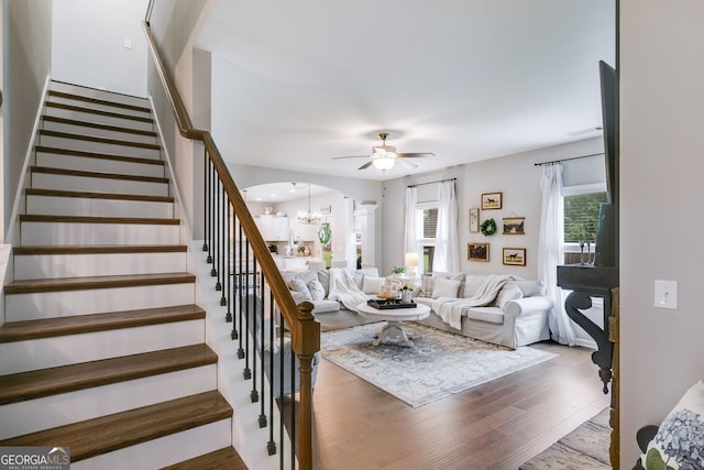 13 Westbrook Rd, Carrollton, GA 30116 - living area with arched walkways, ceiling fan, stairway, a chandelier, and wood finished floors
