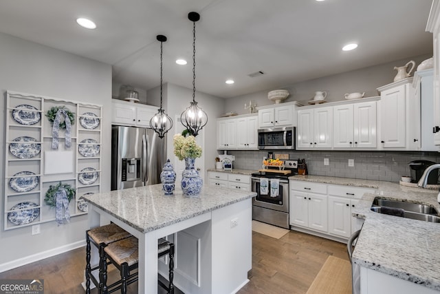 13 Westbrook Rd, Carrollton, GA 30116 - kitchen featuring appliances with stainless steel finishes, a kitchen island, a breakfast bar, white cabinets, and recessed lighting