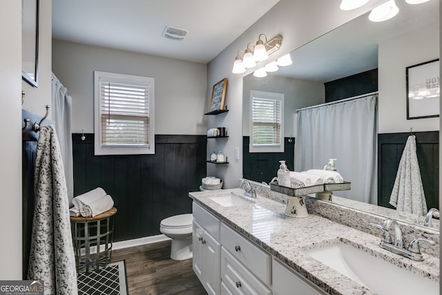 13 Westbrook Rd, Carrollton, GA 30116 - bathroom featuring plenty of natural light, wainscoting, double vanity, wood finished floors, and a shower with shower curtain