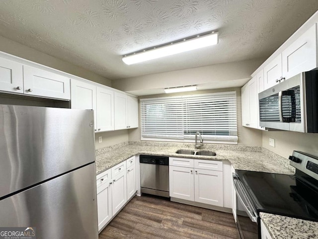 1918 Leigh Dr SW, Conyers, GA 30094 - kitchen with appliances with stainless steel finishes, a sink, white cabinets, and a textured ceiling
